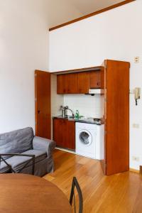 een woonkamer met een bank en een wasmachine bij Nice one bedroom in historical building in Florence