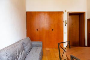 een woonkamer met een bank en een houten deur bij Nice one bedroom in historical building in Florence