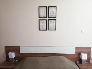 a bedroom with a white wall with four pictures on it at Dobi's Apartment Elit47 at Elit Pamporovo in Pamporovo