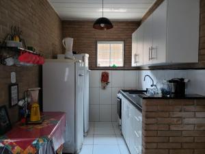 una cucina con armadietti bianchi e frigorifero bianco di Meu lugar sana a Sana