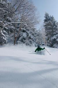a person is skiing down a snow covered slope at AIBIYA in Yamanouchi