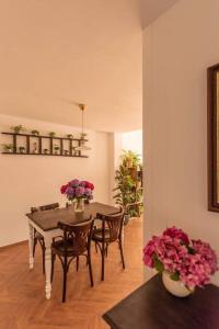 - une salle à manger avec une table, des chaises et des fleurs dans l'établissement Authentieke vakantiewoning op 200 m van het strand, à La Panne