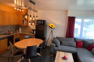 a kitchen and a living room with a couch and a table at Haus Linaria - CharmingStay in Flumserberg