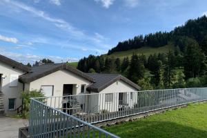 a house with a fence in front of a mountain at Haus Linaria - CharmingStay in Flumserberg