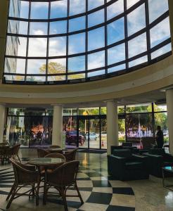 een lobby met tafels en stoelen en een groot raam bij Tropical Executive Hotel Flats in Manaus