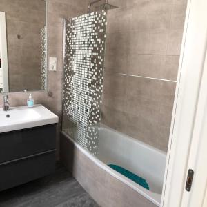 łazienka z prysznicem, wanną i umywalką w obiekcie Apartamentos MareaBeach w mieście Torremolinos +17 zdjęć
