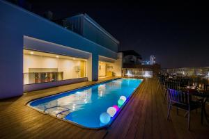 a swimming pool on the deck of a building at night at Zion - A Luxurious Hotel in Bangalore