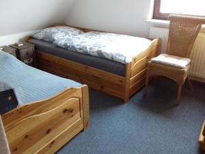 1 Schlafzimmer mit 2 Einzelbetten und einem Stuhl in der Unterkunft Ferienwohnung, Monteurwohnung bis 6 Personen in Rottorf