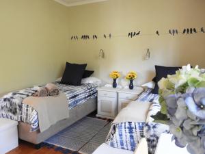 
a hotel room with a bed, desk, and table at Rest Inn Knysna in Knysna
