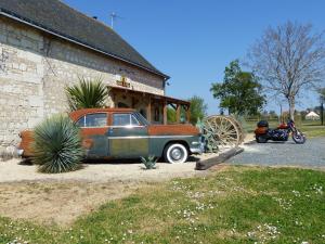 an old car parked in front of a building at La sacristie in Nouâtre