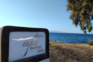 a sign in front of a body of water at En Plo Boutique Suites in Oia