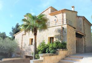 un bâtiment avec un palmier devant dans l'établissement Villa Lara, à Sa Pobla