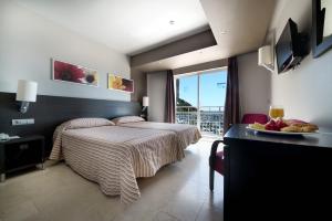 a bedroom with a bed and a table with a plate of fruit at Hotel Porto Calpe in Calpe