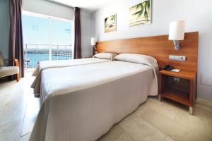 a hotel room with two beds and a window at Hotel Porto Calpe in Calpe