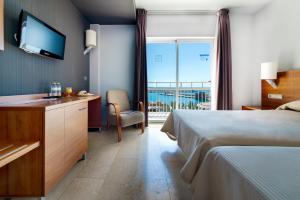 a hotel room with a bed and a view of the ocean at Hotel Porto Calpe in Calpe