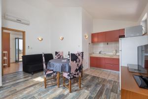 uma cozinha e uma sala de jantar com mesa e cadeiras em Apartment Doris em Supetarska Draga
