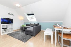 ein Wohnzimmer mit einem Sofa und einem Tisch in der Unterkunft Ferienwohnungen im Haus Lieblingskoje in Neuharlingersiel