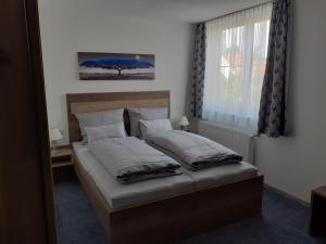 een slaapkamer met een bed met kussens en een raam bij Landgasthof Hotel Lamm in Laichingen