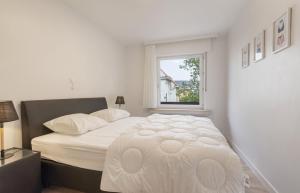 um quarto com uma grande cama branca e uma janela em De Boei - Koksijde em Koksijde