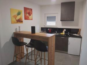 a kitchen with a wooden table and bar stools at Gold Apartmani Kozarac in Kozarac