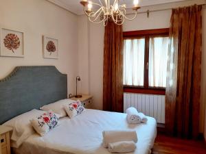una camera da letto con due letti e un lampadario di APARTAMENTO CON JARDÍN MARBLÉS a Ezcaray