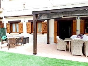 a patio with a table and chairs and awning at APARTAMENTO CON JARDÍN MARBLÉS in Ezcaray