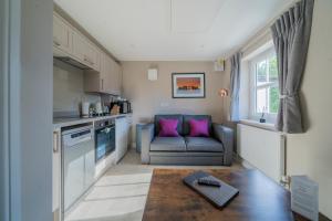 eine Küche mit einem Sofa und einem Tisch in einem Zimmer in der Unterkunft Peartree Serviced Apartments in Salisbury