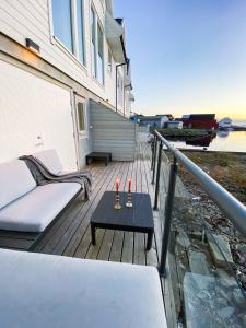 una terraza con sofá y mesa en una casa en New Åkrahamn coast house en Sæveland