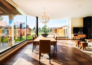 a dining room with a table and a large window at Quercia Houses in Viana do Castelo in Viana do Castelo