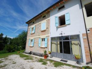 a brick house with blue windows and a yard at Holiday Home Busani by Interhome in Castello di Contignaco