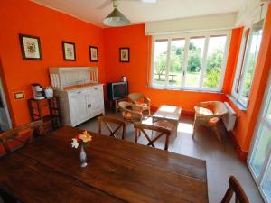 a living room with orange walls and a wooden table at Holiday Home Busani by Interhome in Castello di Contignaco +37 photos
