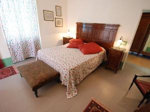 a bedroom with a bed with red pillows on it at Holiday Home Busani by Interhome in Castello di Contignaco