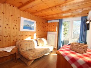ein Wohnzimmer mit einem Sofa und einem Stuhl in der Unterkunft Apartment Alpenland-1 by Interhome in Seefeld in Tirol