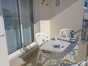 ポンタィヤックにあるApartment Terrasses de Pontaillac by Interhomeの窓付きの客室で、白いテーブルと椅子が備わります。
