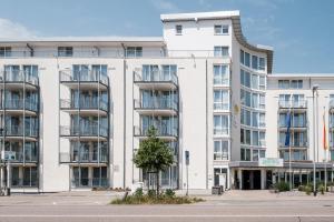 un gran edificio blanco con un árbol delante en Hotel Residenz Pforzheim, en Pforzheim