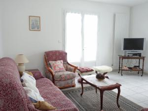 a living room with a couch and a chair at Holiday Home La Roquille by Interhome in Pontaillac