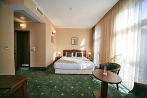 a hotel room with a bed and a table at Retro Hotel in Haskovo