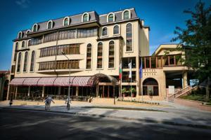 a large white building with people walking in front of it at Retro Hotel in Haskovo