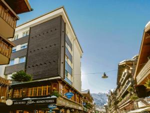 un edificio alto en una calle en una ciudad en Apartment Center by Interhome, en Zermatt