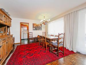 Apartment Center by Interhome في زيرمات: غرفة طعام مع طاولة وسجادة حمراء