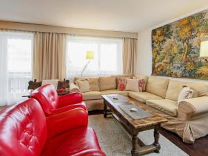- un salon avec un canapé et un fauteuil rouge dans l'établissement Apartment Center by Interhome, à Zermatt