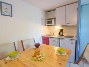 a kitchen with a wooden table with a plate of bread at Holiday Home Les Jardins de l'Océan-2 by Interhome in Pontaillac