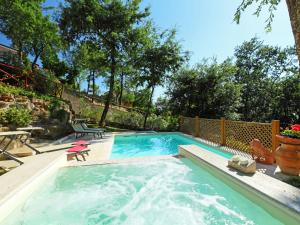 a swimming pool with a table and a chair in a yard at Villa Oleandra sul Lago by Interhome in San Feliciano