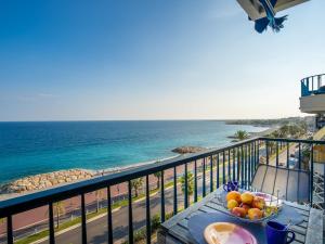 a table with a bowl of fruit on a balcony with the ocean at Apartment Copacabana Promenade des Anglais by Interhome in Nice