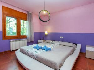 ミアミ・プラトーヤにあるVilla Rustical Mont Roig by Interhomeの紫の壁のベッドルーム1室(大型ベッド1台付)