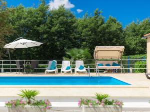 een zwembad met stoelen en een parasol bij Holiday Home Liberat by Interhome in Pazin +48 foto's