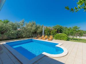 a swimming pool in a yard with chairs around it at Holiday Home Cherry - MDN149 by Interhome in Ližnjan