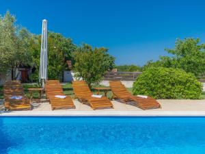 a group of chairs and a table next to a pool at Holiday Home Cherry - MDN149 by Interhome in Ližnjan