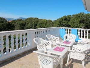 een wit balkon met witte stoelen en een tafel bij Apartment Mira-2 by Interhome in Pinezici