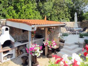 een achtertuin met een pizza-oven en een patio bij Apartment Mira-2 by Interhome in Pinezici